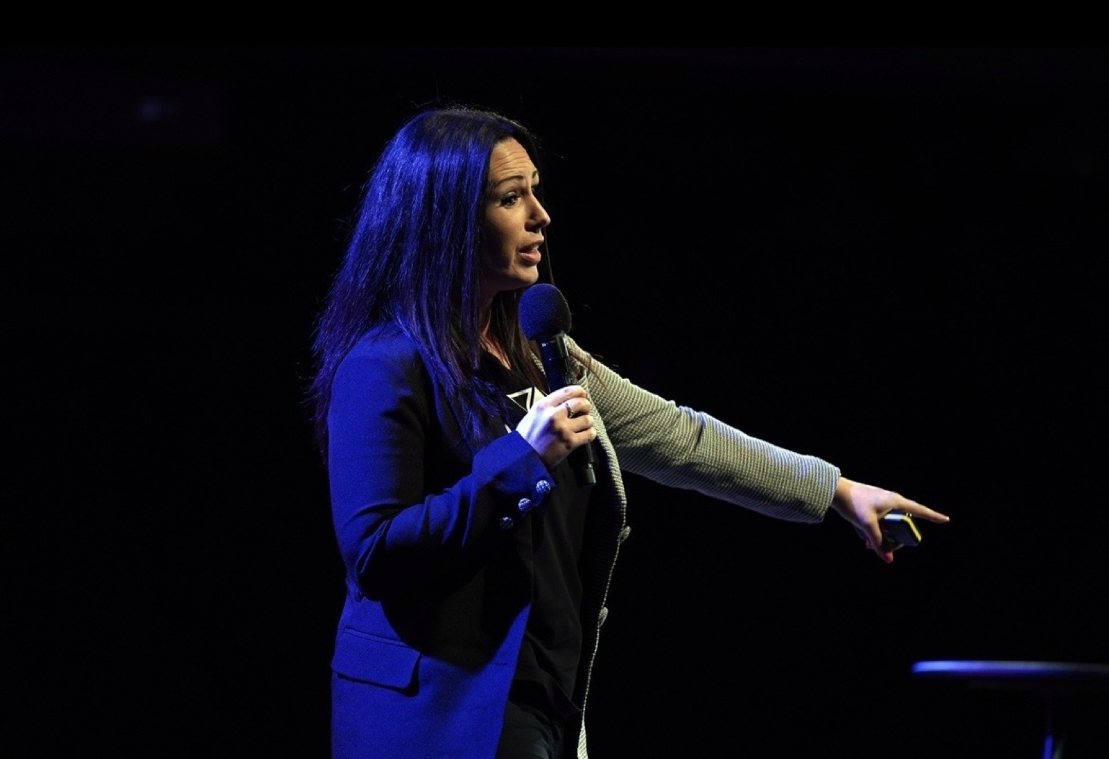 Sadie Restorick on stage, mid-keynote in front of a large audience